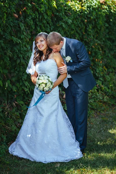 Gelin ve damat gün açık havada yürüyüş düğününde Doğa bahar. Gelin çift, mutlu yeni evli çift yeşil park kucaklayan. — Stok fotoğraf