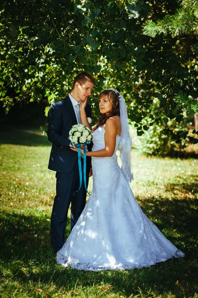 Gelin ve damat gün açık havada yürüyüş düğününde Doğa bahar. Gelin çift, mutlu yeni evli çift yeşil park kucaklayan. — Stok fotoğraf