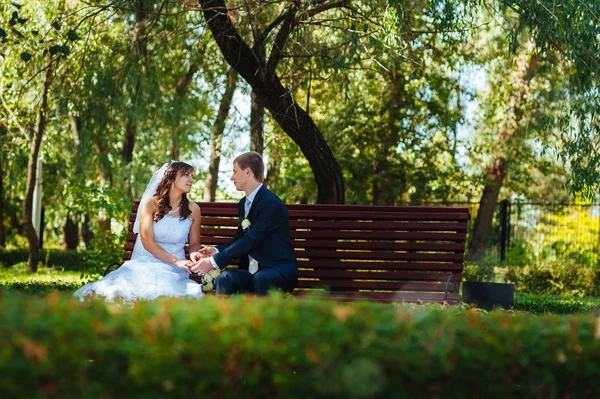 Menyasszony és a vőlegény az esküvő nap séta kint a tavaszi természet. Nászutas pár, boldog Newlywed pár átfogó zöld park. — Stock Fotó