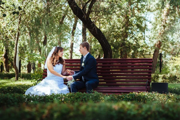 Menyasszony és a vőlegény az esküvő nap séta kint a tavaszi természet. Nászutas pár, boldog Newlywed pár átfogó zöld park. — Stock Fotó