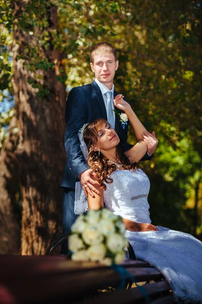 Nevěsty a ženicha na svatební den chůze venku na jarní přírody. Svatební pár, Happy novomanželský pár objímat v parku. — Stock fotografie