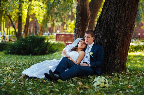 Жених и невеста на свадьбе прогулки на природе весной. Свадебная пара, счастливая молодожёны обнимаются в зеленом парке . — стоковое фото