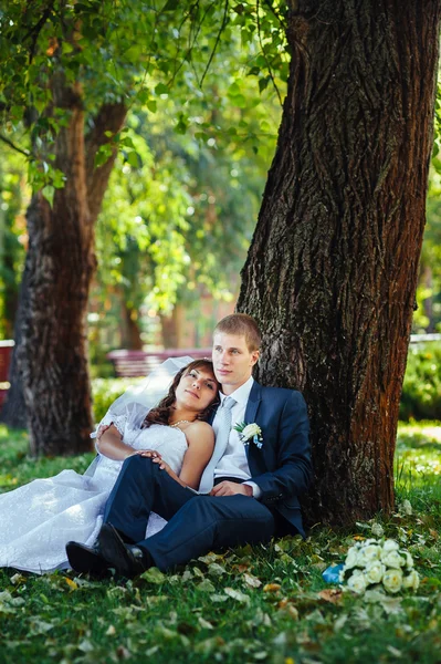 Noiva e noivo no dia do casamento andando ao ar livre na natureza de primavera. Casal nupcial, casal recém-casado feliz abraçando no parque verde . — Fotografia de Stock