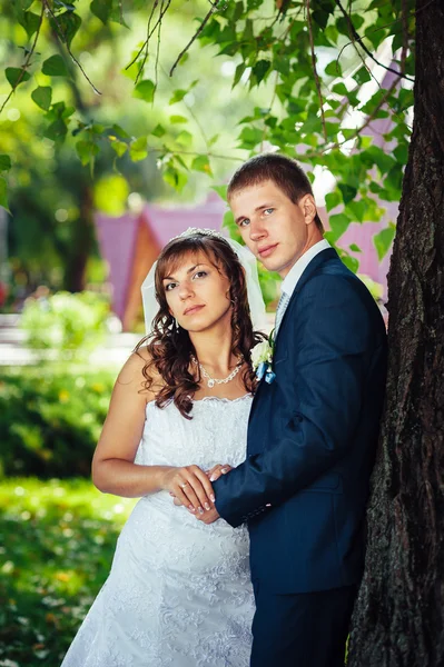 Gelin ve damat gün açık havada yürüyüş düğününde Doğa bahar. Gelin çift, mutlu yeni evli çift yeşil park kucaklayan. — Stok fotoğraf