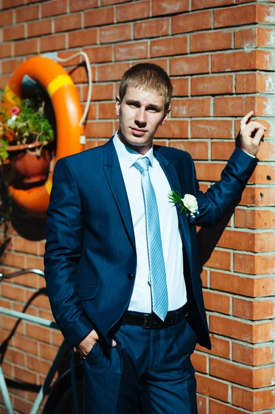 Feliz guapo novio caucásico en esmoquin pensando y poniéndose su corbata . —  Fotos de Stock