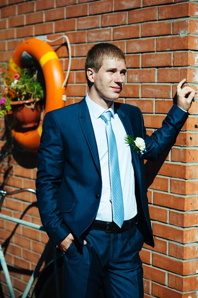 Feliz guapo novio caucásico en esmoquin pensando y poniéndose su corbata . —  Fotos de Stock