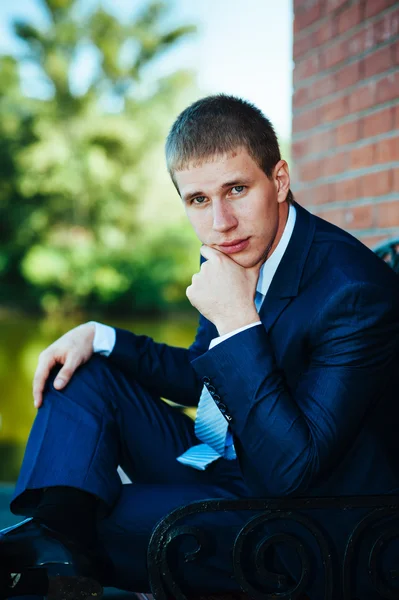 Feliz guapo novio caucásico en esmoquin pensando y poniéndose su corbata . —  Fotos de Stock