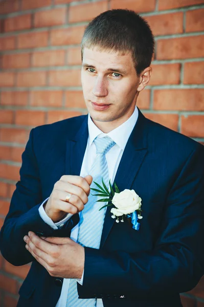 Happy Handsome caucasian groom in tuxedo thinking and putting on his bowtie. — Stock Photo, Image