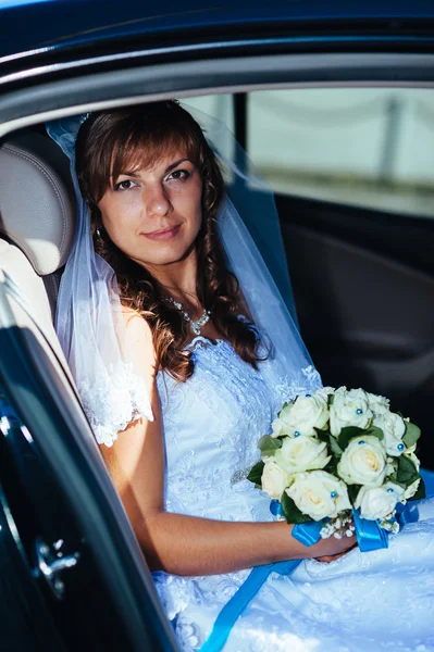 Close-up portrait of pretty shy bride in a car window — Stock Photo, Image