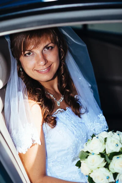 Portrait en gros plan d'une jolie mariée timide dans une fenêtre de voiture — Photo