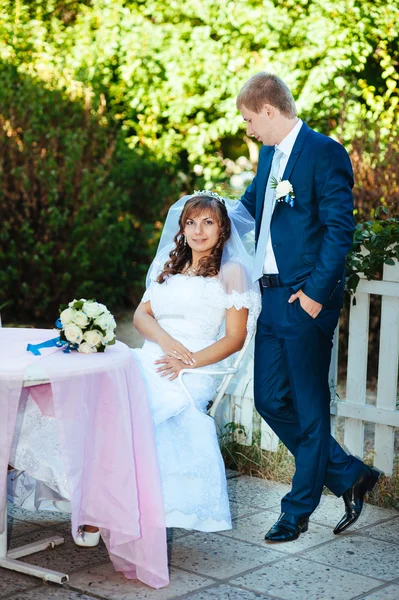 Bruden och brudgummen på bröllop dag promenader utomhus på vår natur. Brudparet, lycklig nygift par omfattar i grön park. — Stockfoto