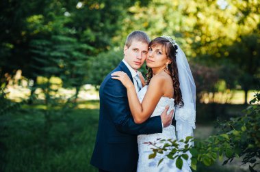 Gelin ve damat gün açık havada yürüyüş düğününde Doğa bahar. Gelin çift, mutlu yeni evli çift yeşil park kucaklayan.