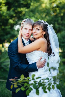 Gelin ve damat gün açık havada yürüyüş düğününde Doğa bahar. Gelin çift, mutlu yeni evli çift yeşil park kucaklayan.