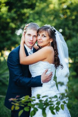 Gelin ve damat gün açık havada yürüyüş düğününde Doğa bahar. Gelin çift, mutlu yeni evli çift yeşil park kucaklayan.