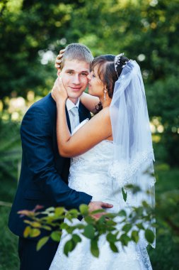 Gelin ve damat gün açık havada yürüyüş düğününde Doğa bahar. Gelin çift, mutlu yeni evli çift yeşil park kucaklayan.