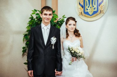 Düğün töreni. Kayıt ofisi. Bir yeni evli çift evlilik belgesi imzalar.