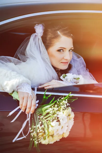 Close-up portrait of pretty shy bride in a car window — Stock Photo, Image