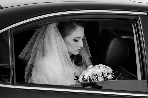 Close-up portrait of pretty shy bride in a car window — Stock Photo, Image