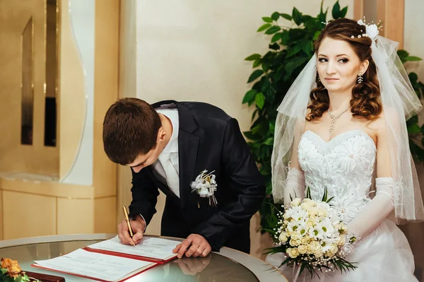 Wedding ceremony. Registry office. A newly-married couple signs the marriage document. — Stock Photo, Image