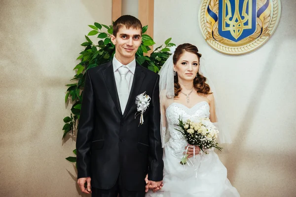 Ceremonia de boda. Oficina de registro. Una pareja de recién casados firma el documento de matrimonio . — Foto de Stock