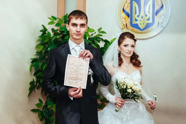 Весільна церемонія. Офіс реєстрації. Щойно одружена пара підписує шлюбний документ . — стокове фото