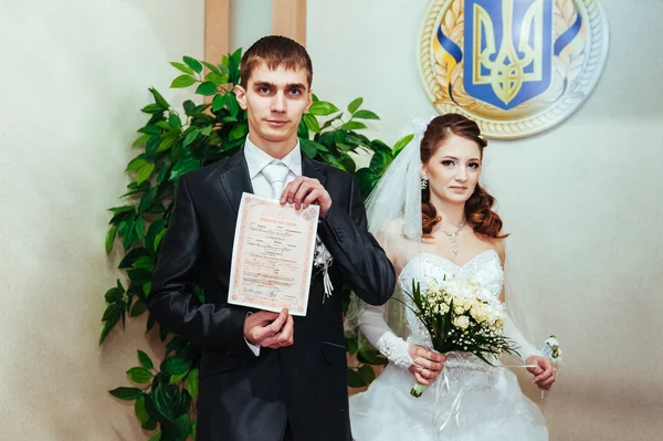 Une cérémonie de mariage. Bureau du greffe. Un couple nouvellement marié signe le document de mariage . — Photo