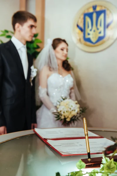 Ślub. Urzędzie stanu cywilnego. Świeżo żonata para podpisuje dokument małżeństwo. — Zdjęcie stockowe