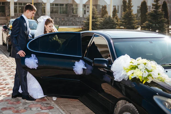 Bride and groom kissing in limousine on wedding-day. — Stock Photo, Image