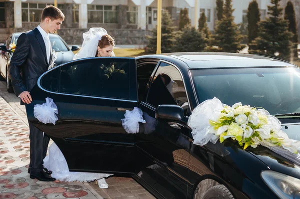 Bruid en bruidegom kussen in limousine op trouwdag. — Stockfoto