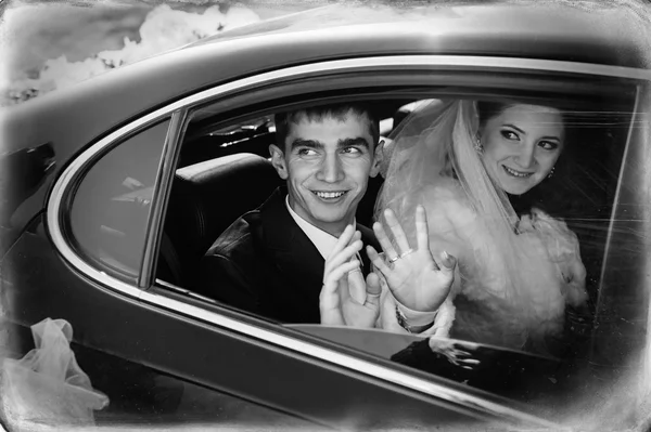 Bruid en bruidegom kussen in limousine op trouwdag. — Stockfoto