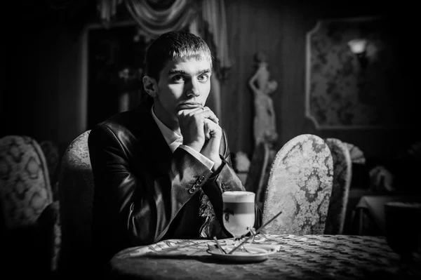 Handsome man drinking coffee at in cafe. Grooms hands holding cup of coffee. — Stock Photo, Image