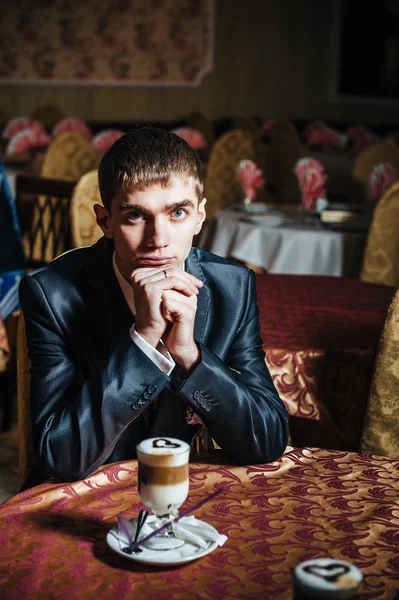 Handsome man drinking coffee at in cafe. Grooms hands holding cup of coffee. — Stock Photo, Image