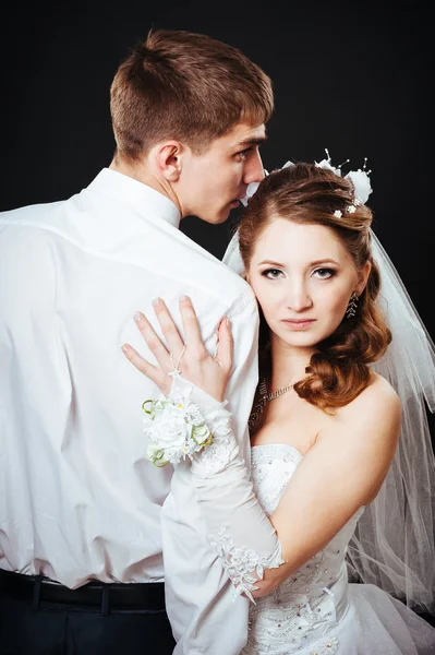 Bruidegom kussen bruid op bruiloft. Zwarte achtergrond. — Stockfoto