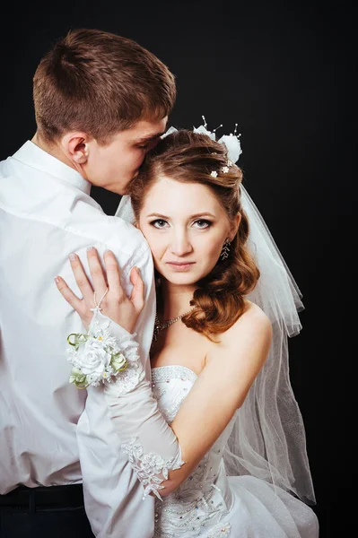 Brudgummen kyssa bruden på bröllopet. Svart bakgrund. — Stockfoto
