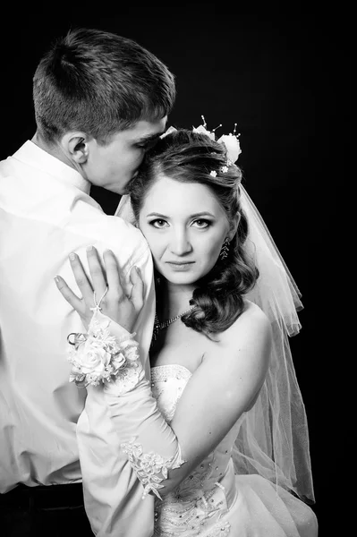 Bräutigam küsst Braut auf Hochzeit. schwarzer Hintergrund. — Stockfoto