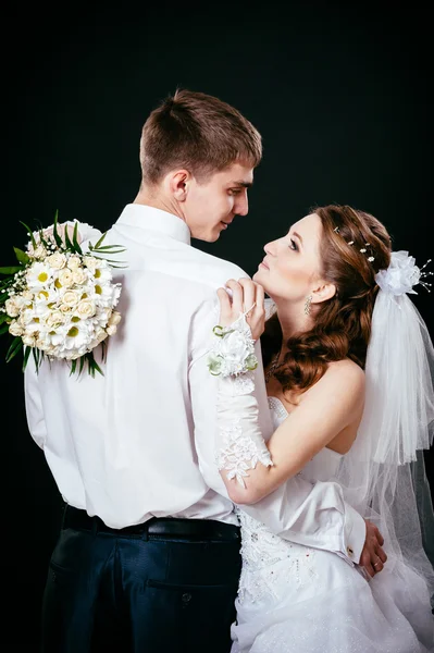 Bruidegom kussen bruid op bruiloft. Zwarte achtergrond. — Stockfoto