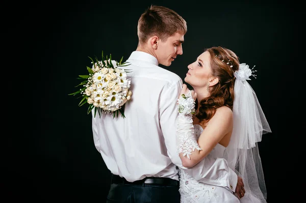 Groom kissing bride on wedding. Black background. — Stock Photo, Image