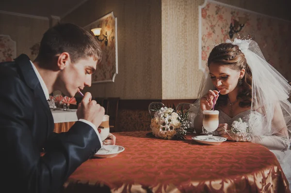 Novia y novio en lujoso restaurante beber taza de capuchino o café con leche con forma de corazón en su boda. Día de San Valentín —  Fotos de Stock