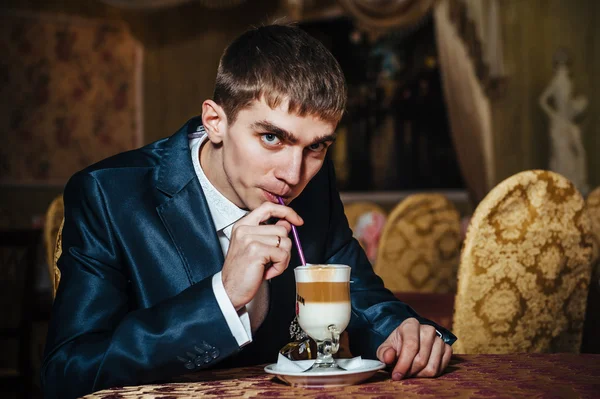 Handsome man drinking coffee at in cafe. Grooms hands holding cup of coffee. — Stock Photo, Image