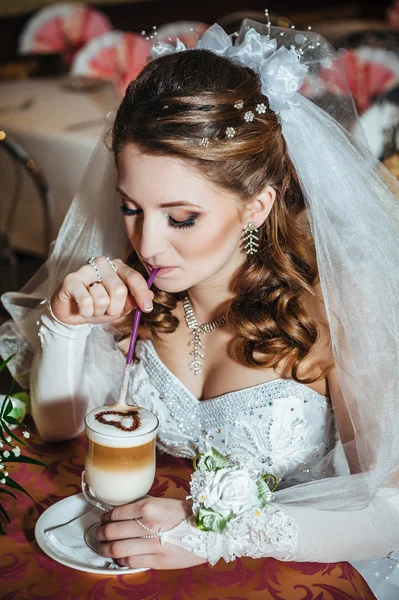 Novia en lujoso restaurante beber taza de capuchino o café con leche con forma de corazón en su boda. Día de San Valentín — Foto de Stock