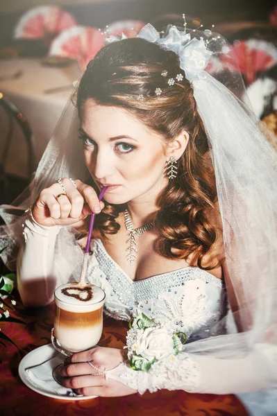 Nevěsta v luxusní restauraci pít šálek Cappuccino nebo latte káva s tvarem srdce na její svatbě. Valentinky den — Stock fotografie