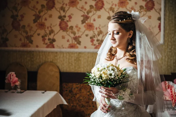 Retrato bela noiva com buquê de flores no interior de luxo no dia do casamento — Fotografia de Stock