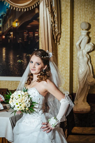 Retrato bela noiva com buquê de flores no interior de luxo no dia do casamento — Fotografia de Stock