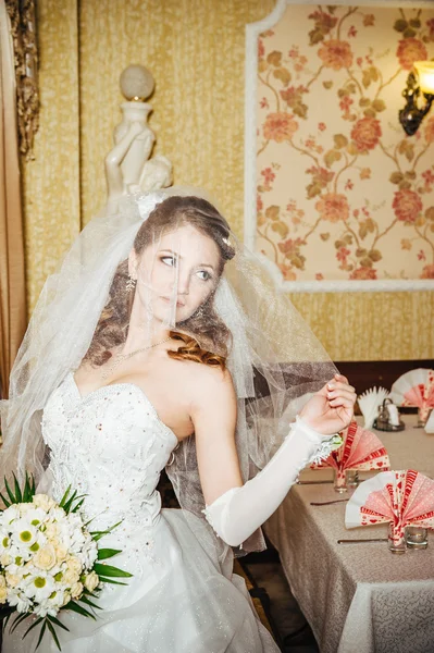 Portret mooie bruid met boeket van bloemen op luxe interieur in trouwdag — Stockfoto