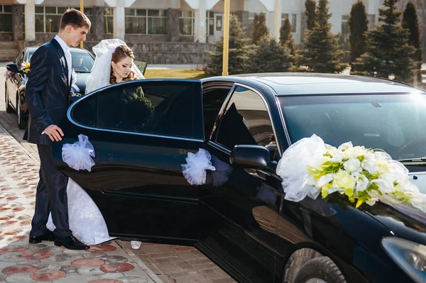 Жених и невеста целуются в лимузине в день свадьбы . Стоковое Изображение