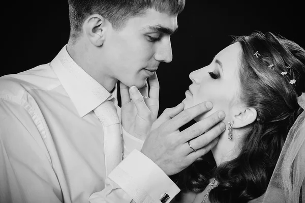 Groom kissing bride on wedding. Black background. Stock Image