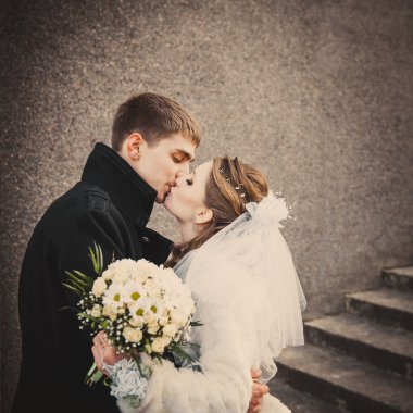 Şık gelin ve damat düğün günü dışarıda birlikte poz veriyorlar.