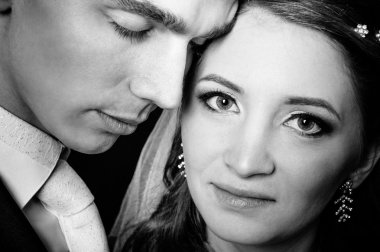 Gelin ve damat öpüşme, sarılma. siyah arka plan üzerine stüdyoda çekilmiş düğün fotoğrafı