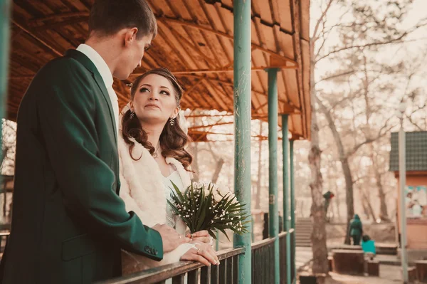 Bruden och brudgummen kramas på sjön i en park. Bröllop vid havet. Smekmånad. — Stockfoto