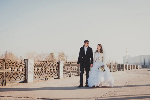 Bruden och brudgummen kramas på sjön i en park. Bröllop vid havet. Smekmånad. — Stockfoto